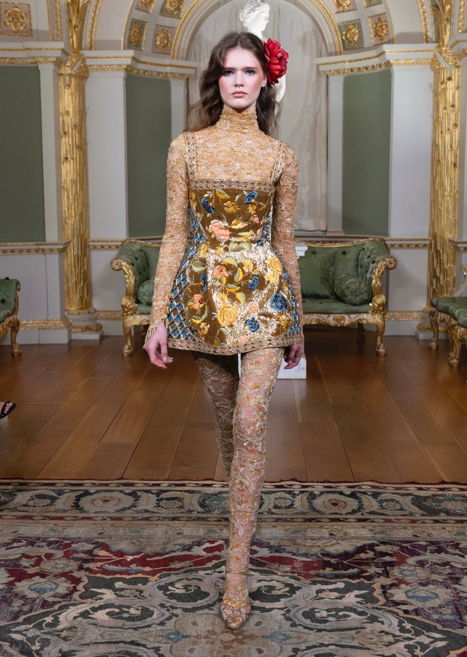 A gold jacquard look with hand-applied metal embellishment, worn on the runway